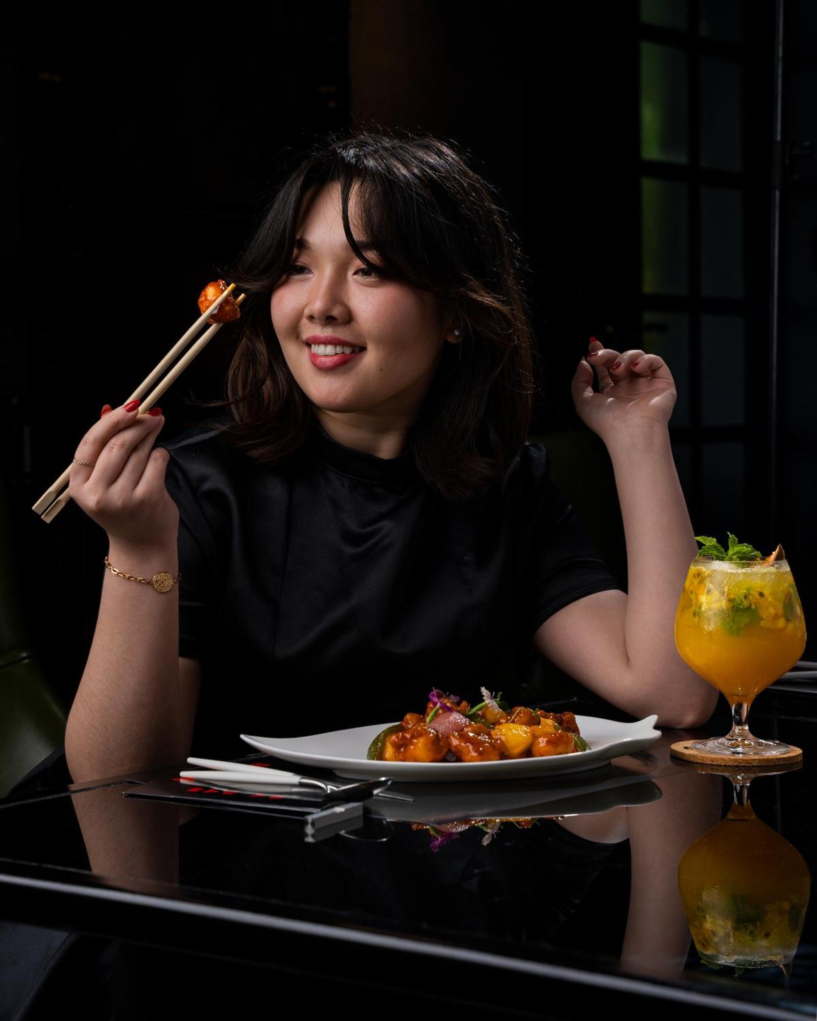 ホテル W マスカット エクステリア 写真 A woman eating with chopsticks